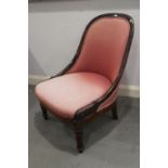A 19th century rosewood showframe low seat nursing chair, upholstered in a pink fabric, on turned