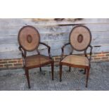 A pair of mahogany Hepplewhite design cane cameo back elbow chairs, on square taper supports