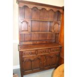 An oak dresser, the upper section fitted two cupboards and open shelves, over three drawers and