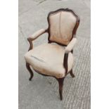 A 19th century carved rosewood showframe armchair, upholstered in a cream brocade, on cabriole