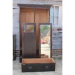 An early 20th century walnut wardrobe enclosed leaded glazed door and mirror panel drawer over one
