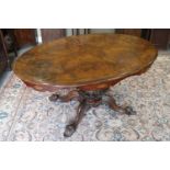 A mid Victorian figured walnut oval loo table, on carved column and four scroll supports, 58" wide x