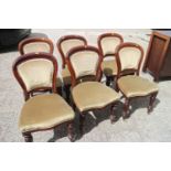 A set of six Victorian mahogany showframe dining chairs with padded seats and backs, on turned and