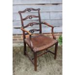 A mahogany ladder back chair of George III design with scroll carved arms and padded seat, on