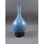 A Chinese blue monochrome sprinkler vase, 10 1/4" high, and associated carved hardwood stand