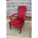 A 19th century rosewood showframe open armchair, upholstered in a cinnabar velour, on turned and