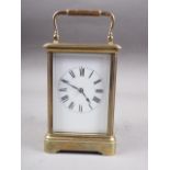 A French brass cased carriage clock with white enamel dial and Roman numerals, 5" high, in leather