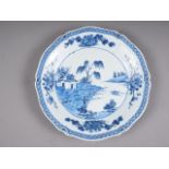 A Chinese blue and white shaped edge dish with landscape decoration and floral borders, 13" dia