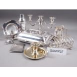 A pair of silver plated entree dishes and covers, a pair of plated three-branch candelabra, a plated