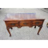 An oak sideboard/carving table, fitted three drawers, on shaped supports, 48" wide x 18" deep x