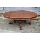 An early 20th century mahogany oval low occasional table, on carved scroll supports, top 54" x 42" x