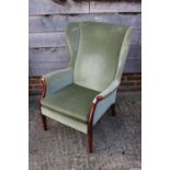 A Parker Knoll showframe wing armchair, upholstered in a sage Dralon, on tapering supports, an