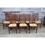 A set of eight oak ladder back dining chairs with rush envelope seats, on turned and stretchered