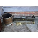 A brass pierced fender curb, 31 1/2" wide, three brass fire irons and an embossed coal scuttle,