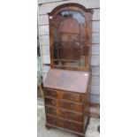 A polished as mahogany arch top bureau bookcase with fall front and fitted interior, over four