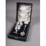 A silver three-piece christening set, egg cup, spoon and napkin ring in fitted case, 1.4oz troy