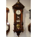 A Vienna regulator type wall clock with eight-day striking movement and white enamel dial, in walnut