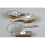 A pair of silver backed brushes with embossed decoration, an Art Deco style silver backed hand