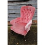 A late 19th century deep seat armchair with carved walnut crest, button upholstered in a pink