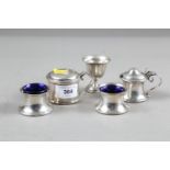 A pair of silver salt cellars with blue glass liners, a similar mustard pot with blue glass