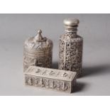 An Indian white metal bottle case with screw top and pierced and embossed decoration, 5 1/4" high, a