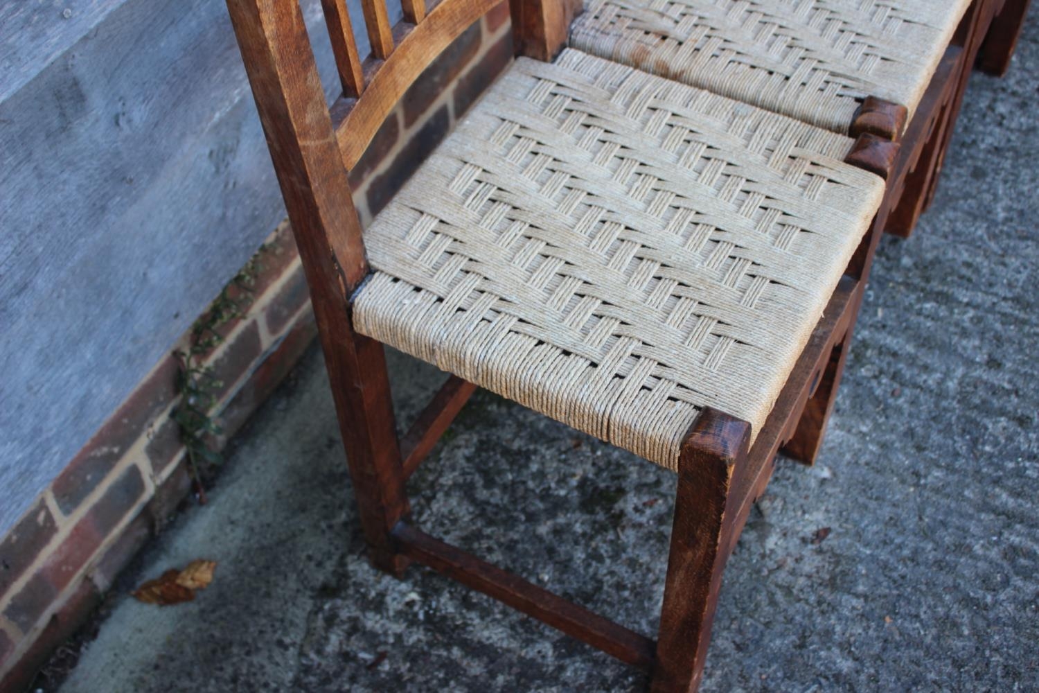 A set of four Spanish oak vertical rail back dining chairs with string seats, on stretchered - Bild 2 aus 3