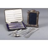 A silver shell shaped tea caddy spoon, an Art Nouveau style silver framed photo frame, a set of