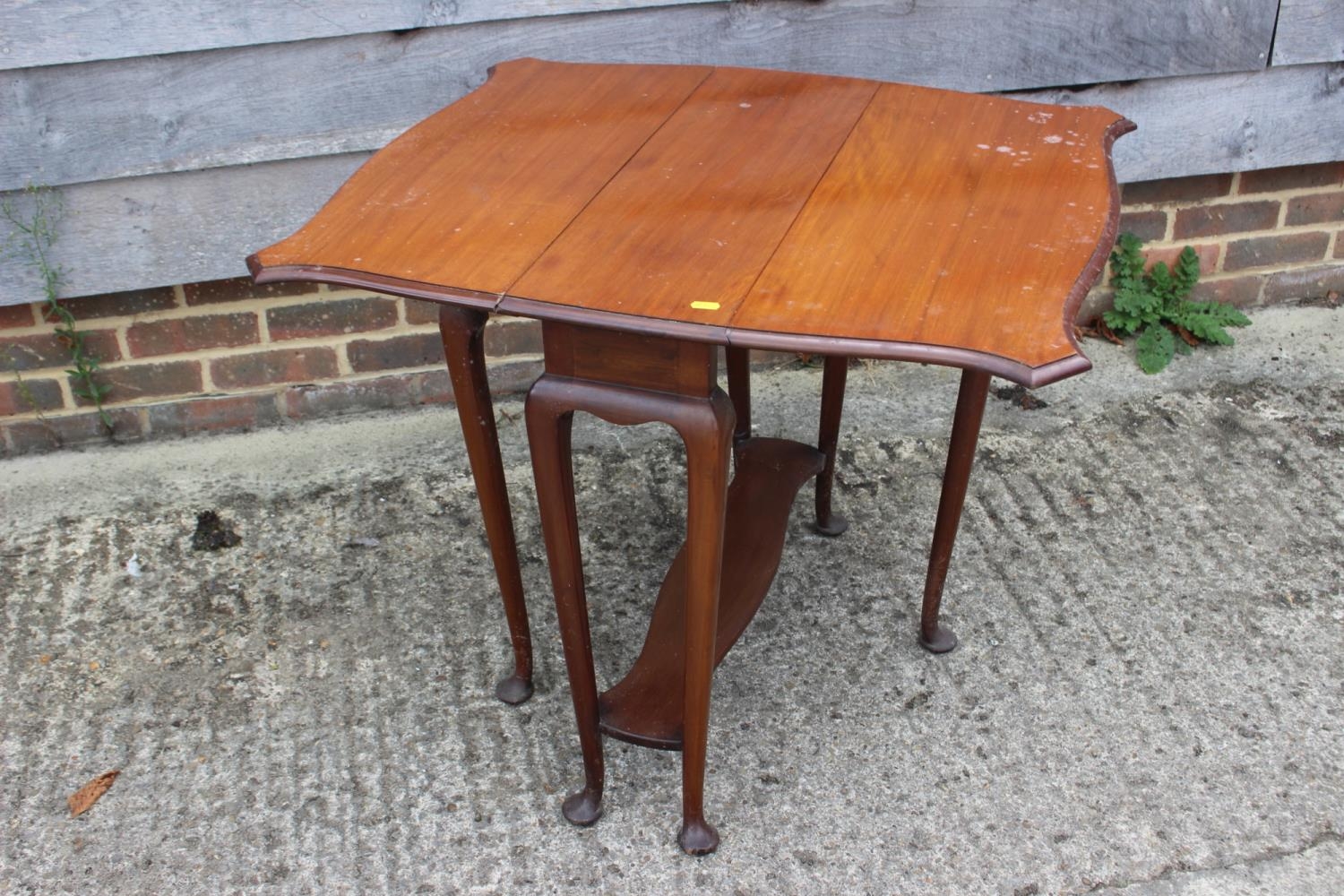 An Edwardian mahogany two-tier Sutherland table, on cabriole supports, 32 1/2" wide x 27" deep x