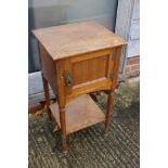 An early 20th century walnut bedside cupboard enclosed one door over undertier, on turned