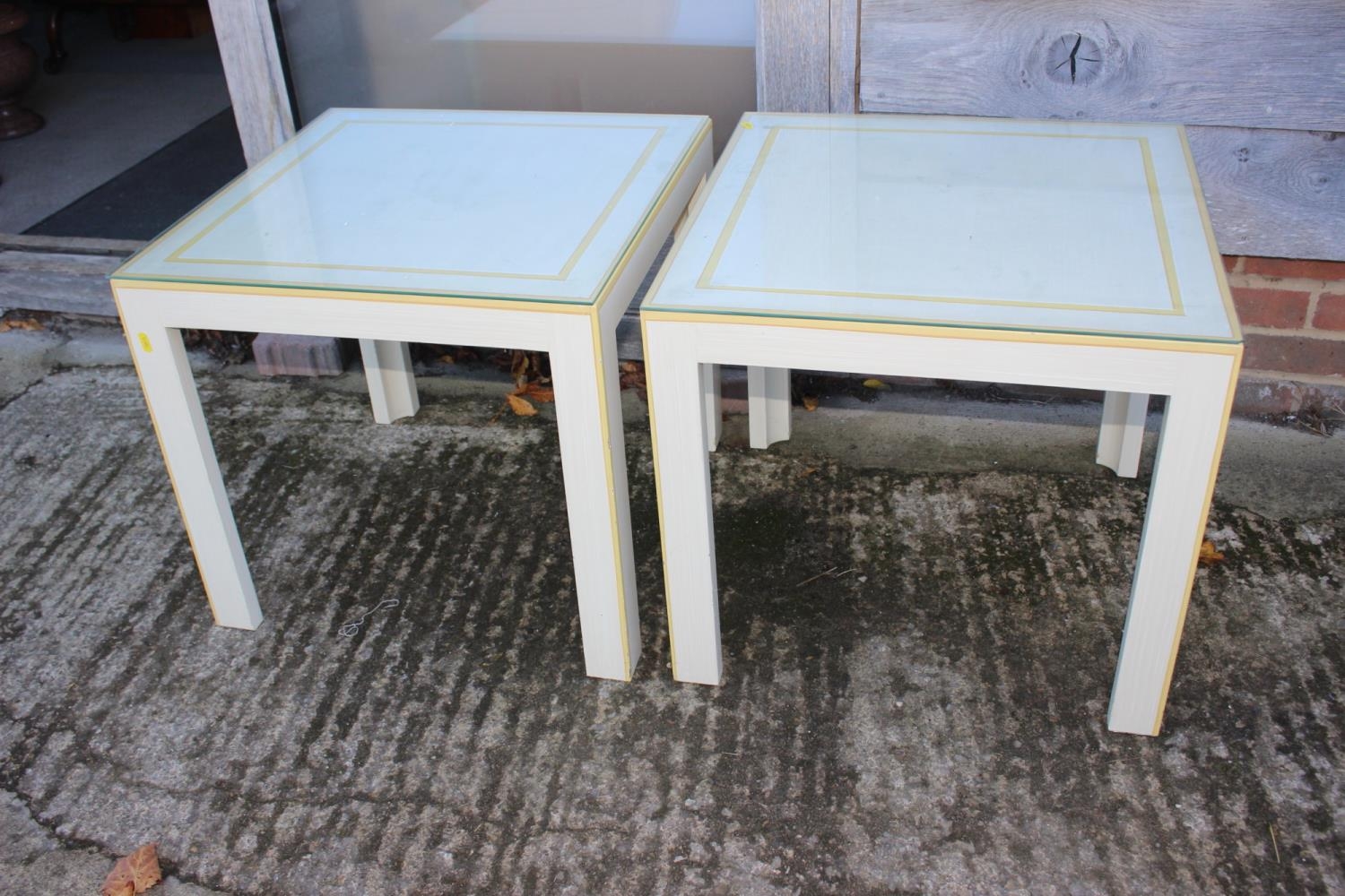 A pair of cream and yellow painted lamp tables, on square supports, 22" wide x 22" deep x 20" high