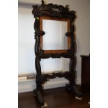 An early 19th century Anglo-Indian carved hardwood fire screen frame with scrollwork design, on