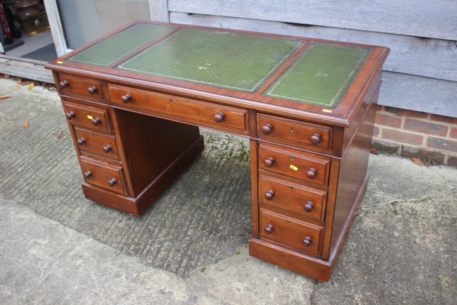 An Edwardian mahogany double pedestal desk with tooled and gilt lined leather top, fitted nine