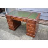 An Edwardian mahogany double pedestal desk with tooled and gilt lined leather top, fitted nine