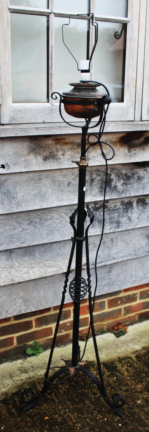 An early 20th century wrought iron standard lamp with copper reservoir, 55" high (now converted to