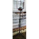 An early 20th century wrought iron standard lamp with copper reservoir, 55" high (now converted to