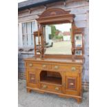 A late 19th century carved oak dresser with raised back mirrors and shelves, over three drawers,