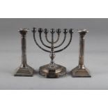 A silver plated menorah with acanthus leaf decoration, on an octagonal stepped base with swag
