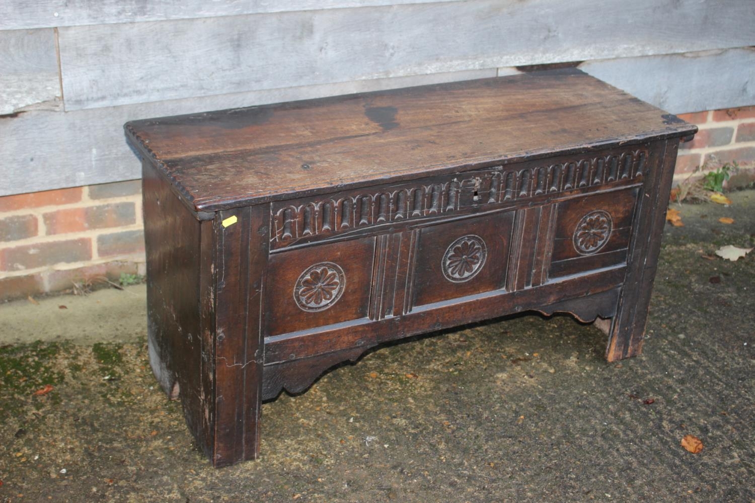 An early 18th century carved oak triple panel front coffer, on panel end supports, 43" wide x 16"
