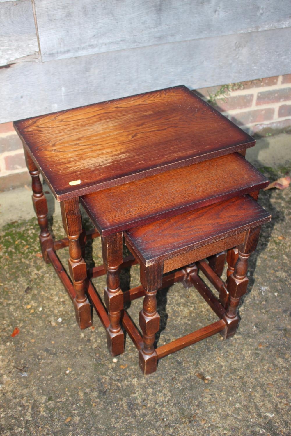 A nest of three oak occasional tables, on turned and stretchered supports, largest 19" wide x 13"