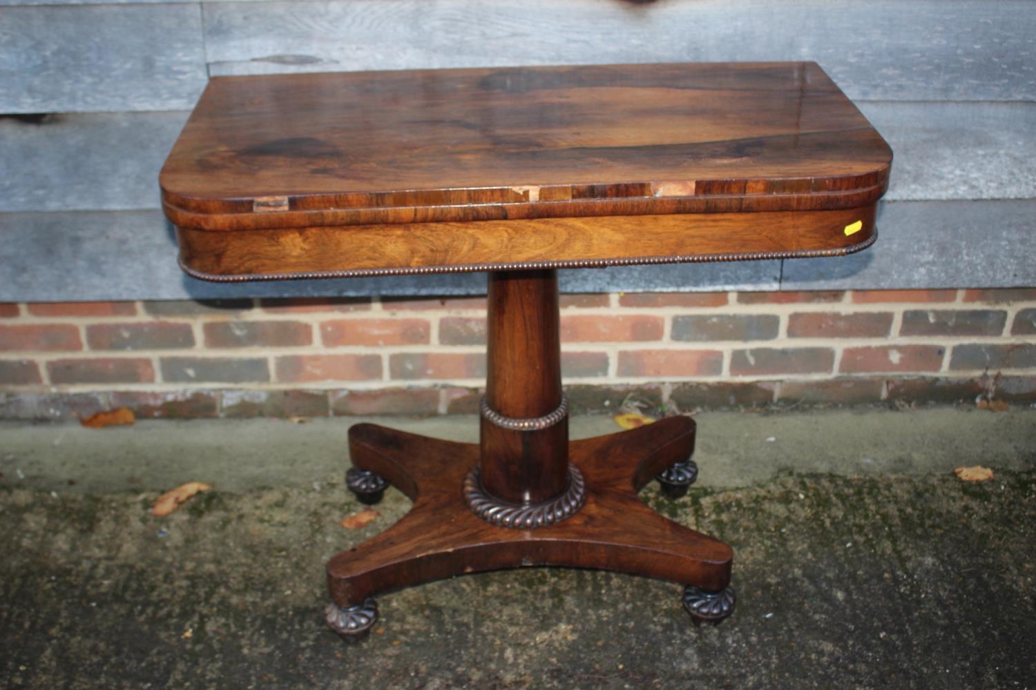 An early 19th century rosewood fold-over top card table, on pedestal and quatreform base, 36" wide