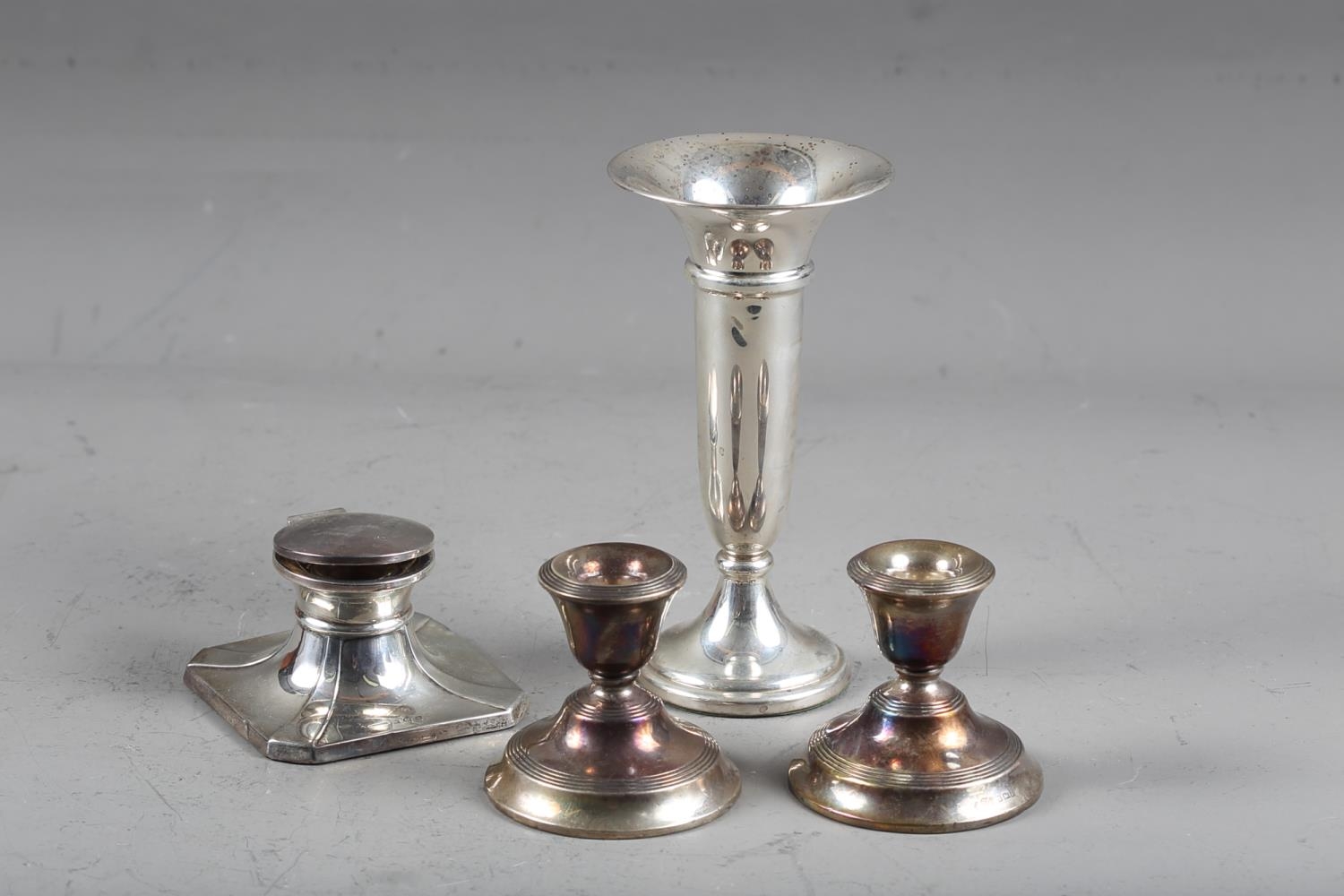 A pair of silver squat candlesticks, 2 3/4" high, a silver trumpet vase with weighted base, 6 1/2"