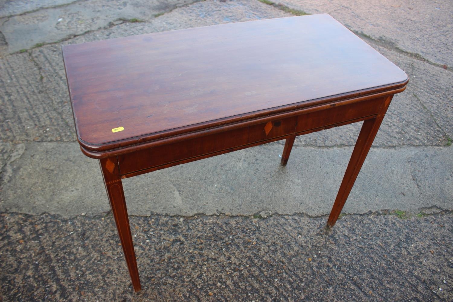 A walnut and banded fold-over top tea table, on square taper supports, 36" wide x 18" deep x 29 1/2"