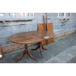 A mahogany and banded double pedestal dining table with two extra leaves, on turned columns and