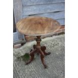 A 19th century walnut circular tilt top occasional table, on turned column and quadruple scroll