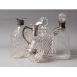An Asprey silver collared decanter and stopper (chipped stopper), a silver collared claret jug (