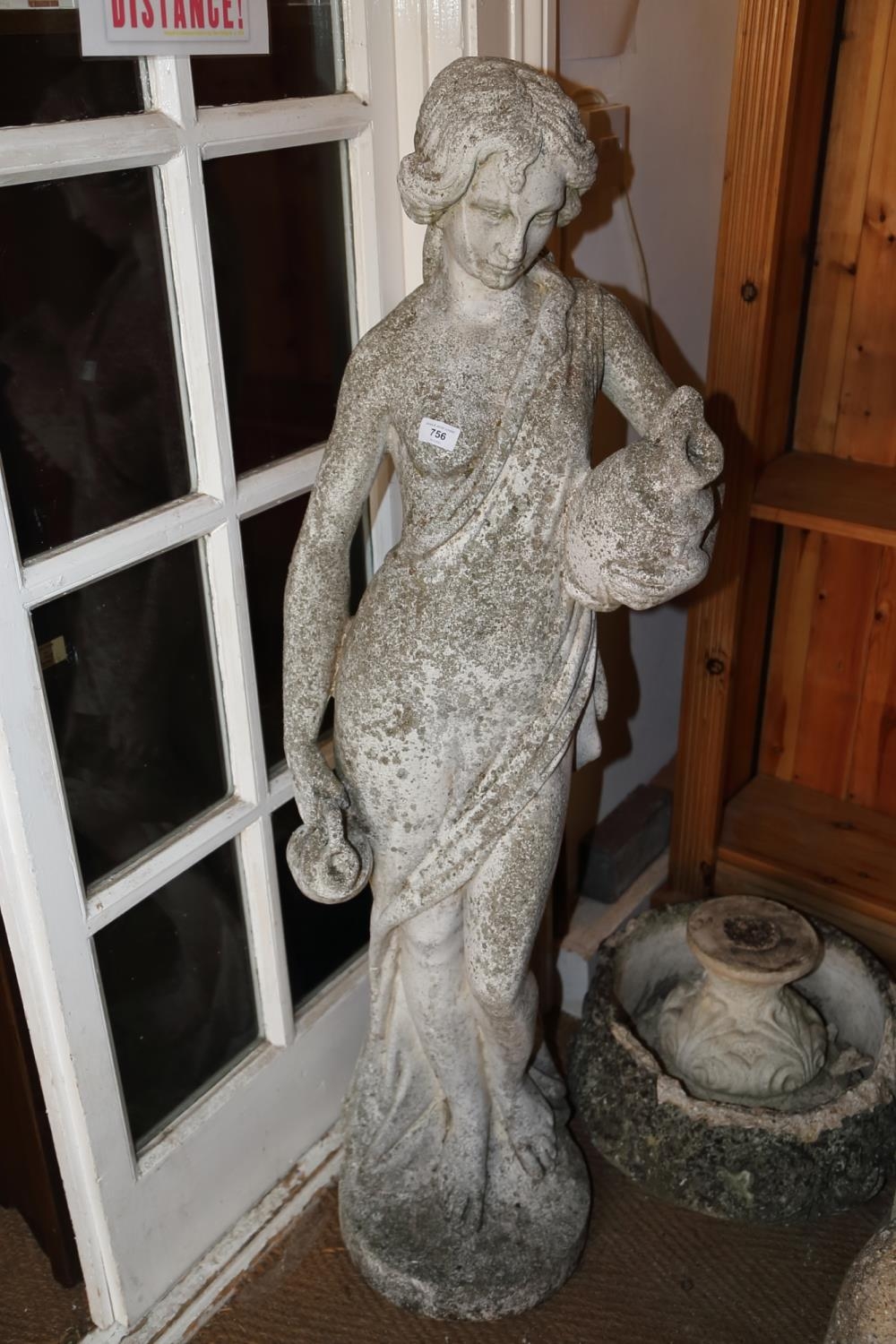 A cast stone figure of a water carrier, 51" high