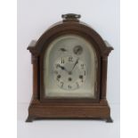 A late Victorian oak cased dome top table clock, silvered arch top dial with Arabic numerals,