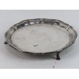 A HM silver card tray raised over three feet, 15.3cm dia, hallmarked Sheffield 1934, 169.4g.