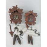 Two black forest cuckoo clock c. early 20th century, each with pendulum and weights.