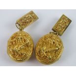 An unusual pair of late 19th / early 20th century Tibetan lockets in untested gilt metal,